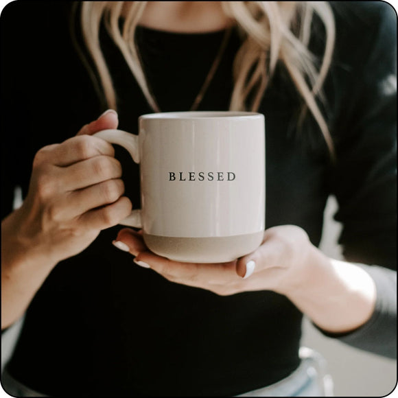 Person holding Blessed stoneware mug with both hands, showcasing its cozy and sturdy design