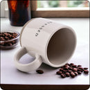 Blessed stoneware mug resting on its side with coffee beans spilling around it, perfect for coffee lovers