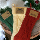 Personalized Christmas stockings with custom engraved patches, featuring Christmas lights, cat, and pawprint with antlers designs, displayed on a festive table