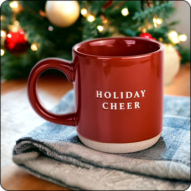 Holiday Cheer stone mug sitting on a table near a Christmas tree, perfect for festive drinks