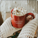 Cozy Holiday Cheer stone mug filled with hot cocoa and whipped cream, being held by a person in a sweater