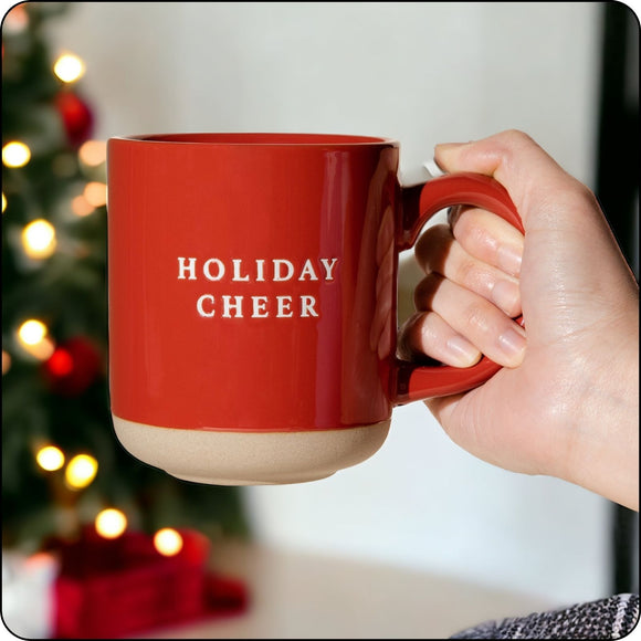 Hand holding a Holiday Cheer stone mug, showcasing its sturdy design and festive charm