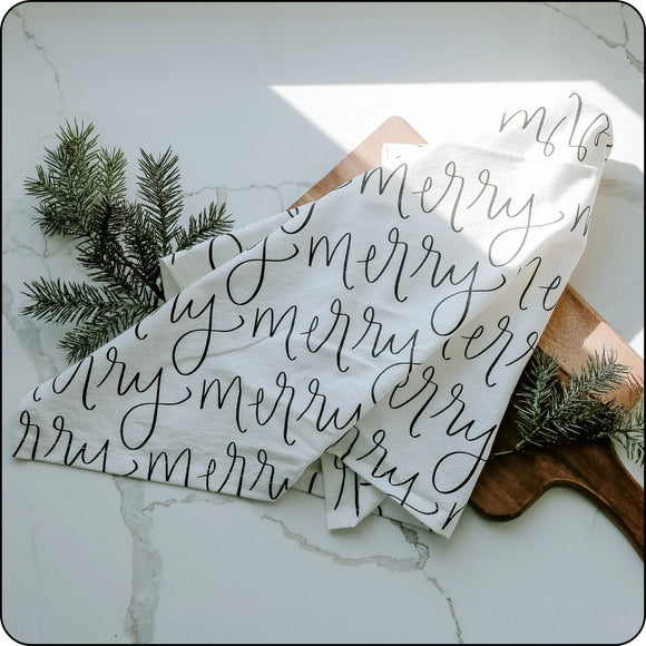 Christmas tea towel with 'Merry' design, displayed flat to show full pattern