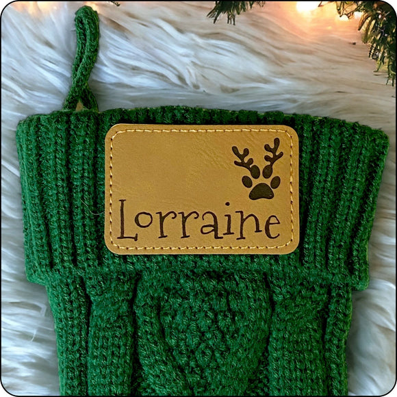 Personalized Christmas stocking featuring a pawprint with antlers design and engraved name patch, great for pet lovers